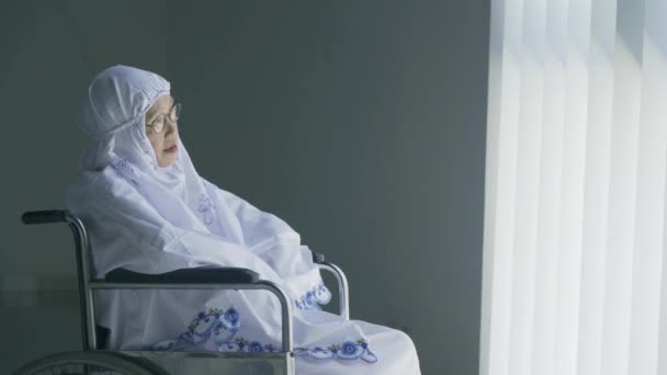 Oudere Vrouw Die Gebedskleren Draagt Terwijl Een Rolstoel Zit — Stockvideo