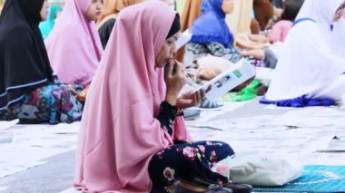 Jakarta, Endonezya. 12 Eylül 2017: dua peçe giyen ve birlikte Sunda Kelapa limanda Kurban Bayramı Günü dua sonra sokakta oturan Müslüman kadınlar