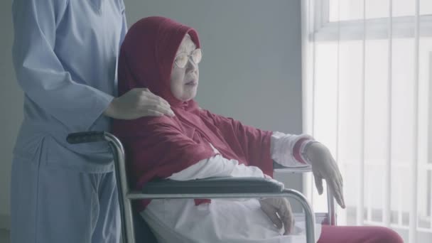 高齢のイスラム教徒の女性は 車椅子に座って脳卒中から回復した後 彼女の看護師によって楽しまれました 4Kの解像度で撮影 — ストック動画