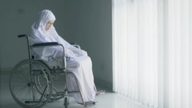 Müslüman kadın tekerlekli sandalyede namaz kılıyor.