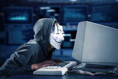 Sistem odasında isimsiz maskeli bir adam yazı yazıyor.