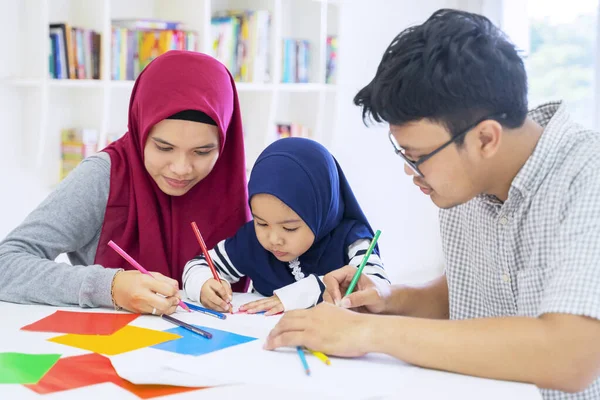 Famiglia musulmana asiatica che disegna su carte origami — Foto Stock