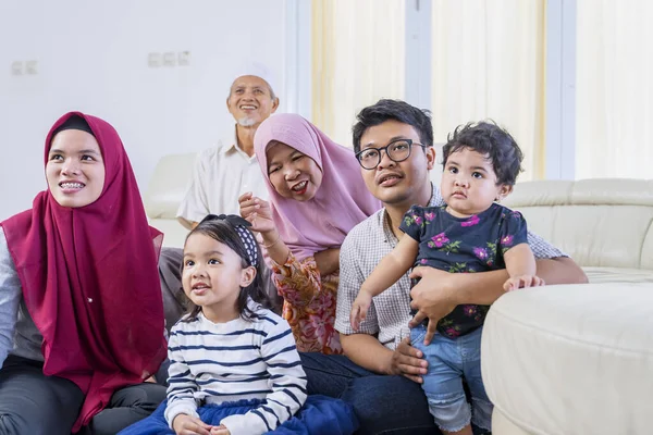 Büyük Müslüman aile mutlu bir şekilde televizyon izliyor. — Stok fotoğraf