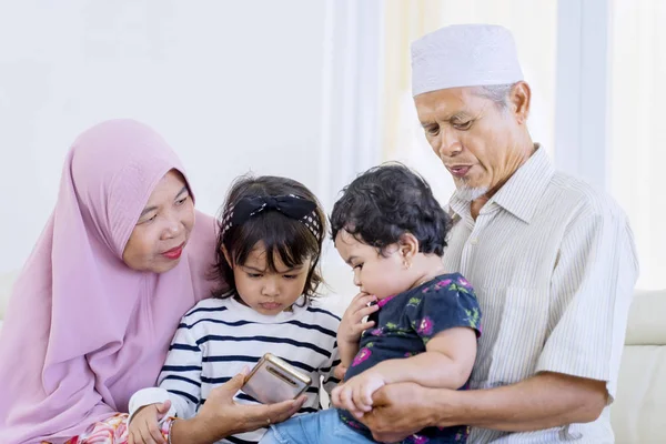 Elderly muslim parents lapping their grandchildren — Stock Photo, Image