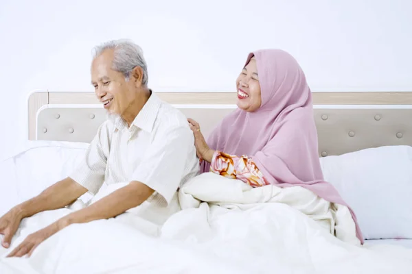 Elderly muslim woman massaging her husband back — Stock Photo, Image