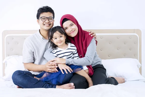 Happy Asian muslim parents hugging their daughter — Stock Photo, Image