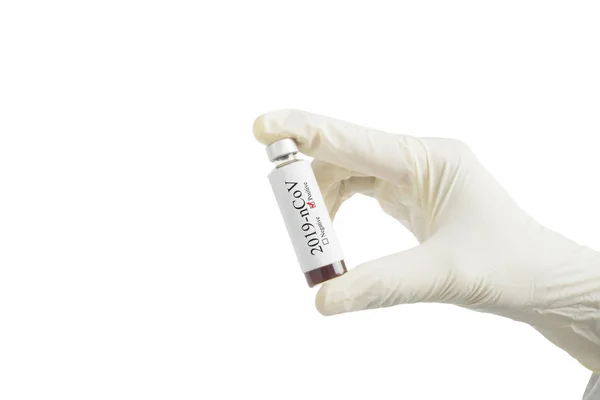 Человеческая рука в перчатке с бутылкой лекарства NCoV — стоковое фото
