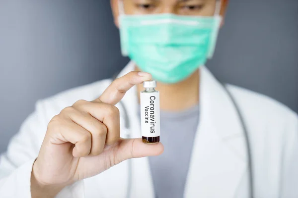 Male doctor holding a coronavirus vaccine bottle — Stock Photo, Image