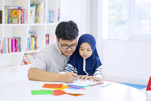 Homem ensinando sua adorável filha a desenhar — Fotografia de Stock