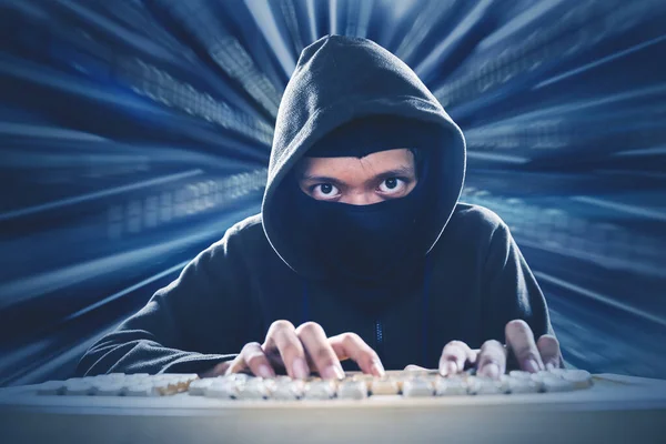Man typing in his desktop fiercely in warp tunnel — Stock Photo, Image