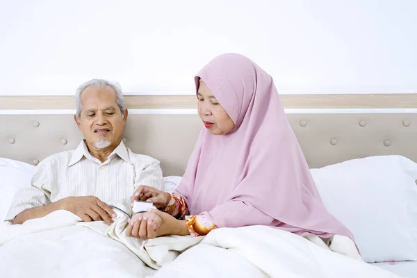 Mujer musulmana midiendo la presión arterial de su marido —  Fotos de Stock