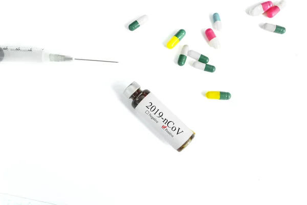 NCoV vaccine bottle with syringe and capsules — Stock Photo, Image