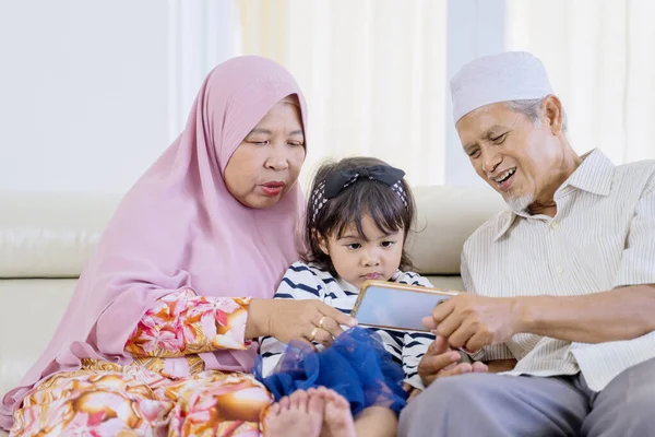 Old parents lapping their grandchild while playing — Stock Photo, Image