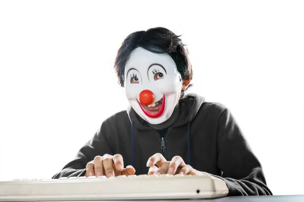 Portret van de mens in clown masker typen op desktop — Stockfoto