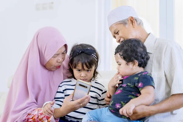 Starší muslimští rodiče olizují svá vnoučata — Stock fotografie