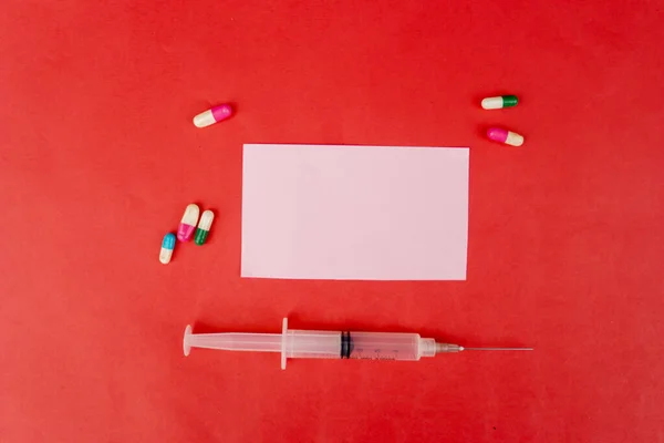 Syringe and capsules around transparent label — Stock Photo, Image