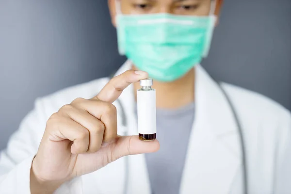 Kimliği belirsiz erkek doktor elinde bir aşı şişesi tutuyor. — Stok fotoğraf