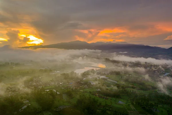 Letecký pohled na vesnici s mlhou při východu slunce — Stock fotografie