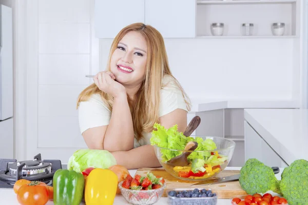 Szőke túlsúlyos nő mosolyog a konyhában — Stock Fotó