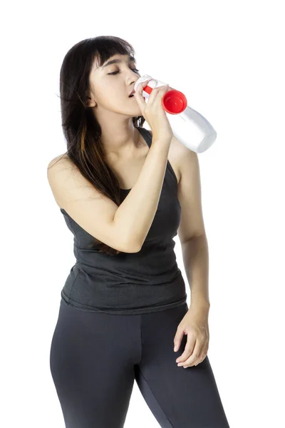 Spor kıyafetli genç bir kadın tatlı su içiyor. — Stok fotoğraf