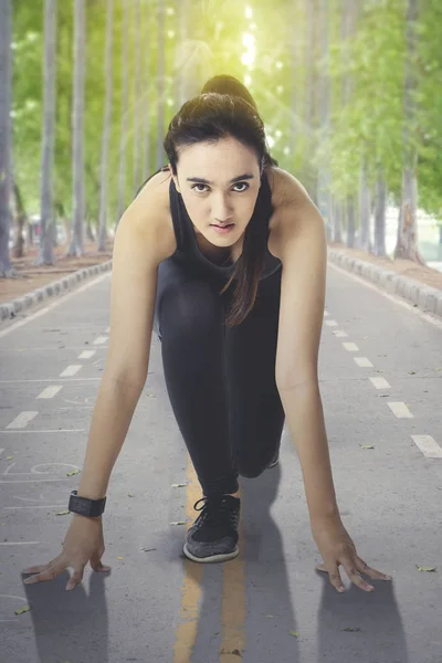 Jovem mulher em sportswear pronto para correr — Fotografia de Stock