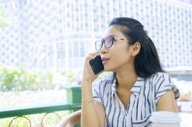 Kafeteryada cep telefonuyla konuşan bir kadın.