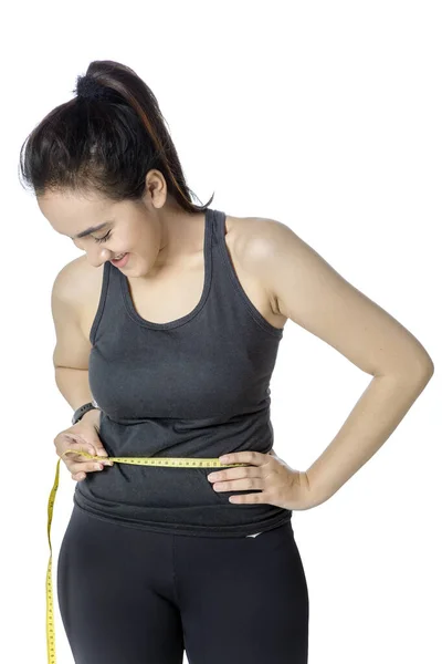 Woman measures waist with a measuring tape — Stock Photo, Image