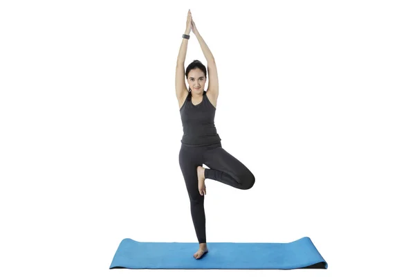 Woman practicing yoga while standing with one leg — Stock Photo, Image