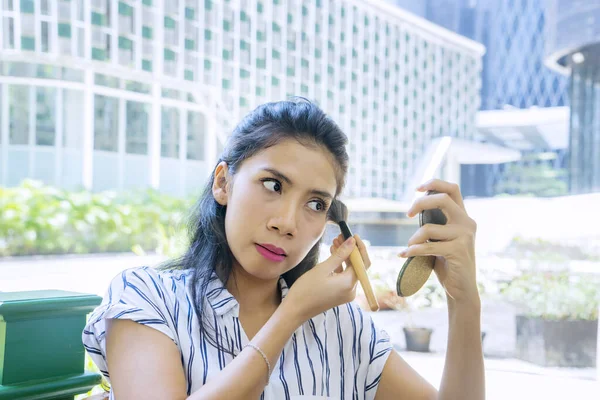 Trabalhadora feminina aplicando fundação de maquiagem — Fotografia de Stock