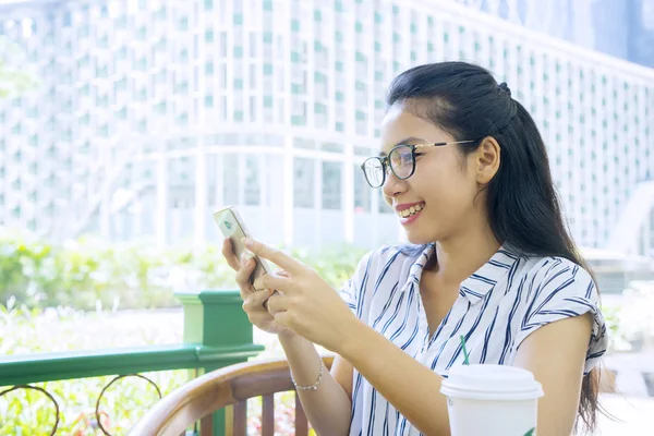 Happy woman reading message on cellphone in cafe — Stock Photo, Image