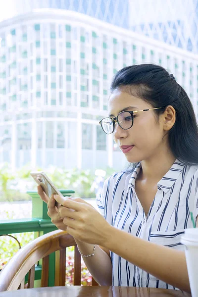 Woman reading message on mobile phone in cafe — Stock Photo, Image