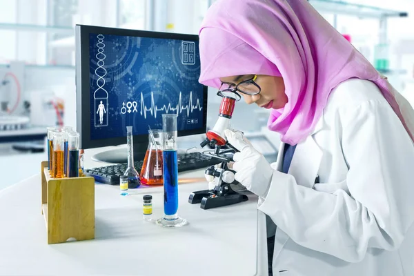 Μουσουλμάνος επιστήμονας που κοιτάζει μέσα από μικροσκόπιο — Φωτογραφία Αρχείου