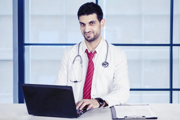 Handsome doctor working with laptop — Stock Photo, Image