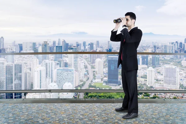 Male businessman using binocular looking for opportunity
