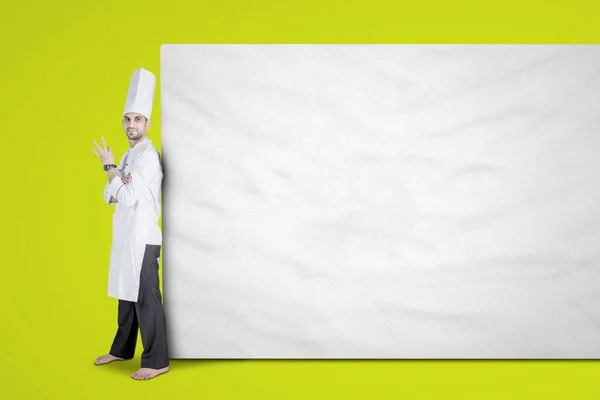 Giovane chef appoggiato su cartellone vuoto — Foto Stock