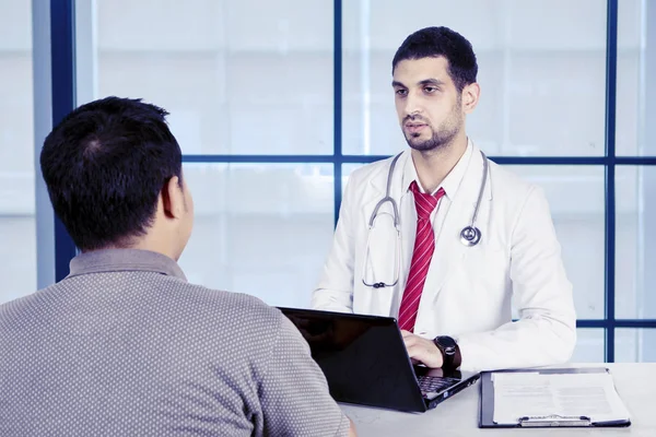 Νεαρός γιατρός μιλάει με τους ασθενείς του — Φωτογραφία Αρχείου