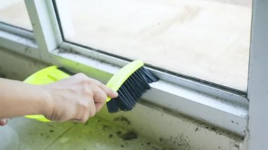 Erkek işçinin elleri tozlu pencereleri temizliyor