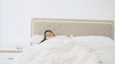 Yaşlı kadın uyanırken sırt ağrısı çekiyor.