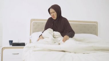 Yaşlı kadın uyanırken diz ağrısı çekiyor.