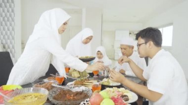 Müslüman bir aile evde yemek yiyor.