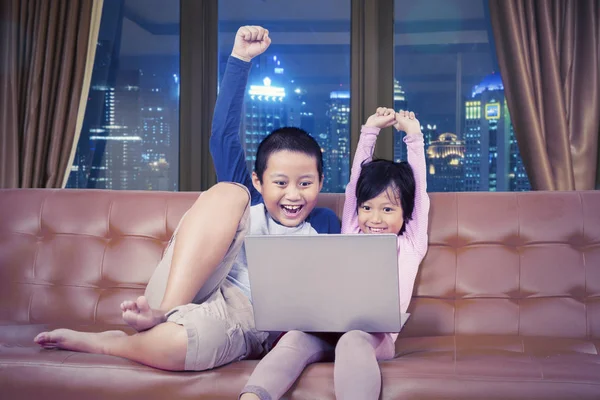 Adorable Asian Kids Cheering While Operating Laptop Living Room Cityscape — Stock Photo, Image