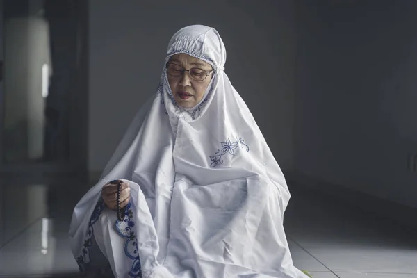 アッラーに祈りながらバラ色のビーズを持つシニアムスリム女性の肖像画 — ストック写真