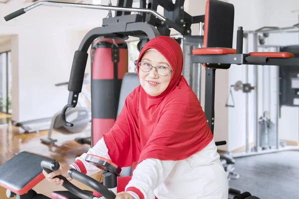 Porträtt Muslimsk Senior Kvinna Ridning Motionscykel Samtidigt Ler Mot Kameran — Stockfoto