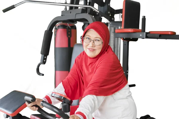 Glückliche Muslimische Seniorin Lächelt Auf Dem Heimtrainer Die Kamera — Stockfoto