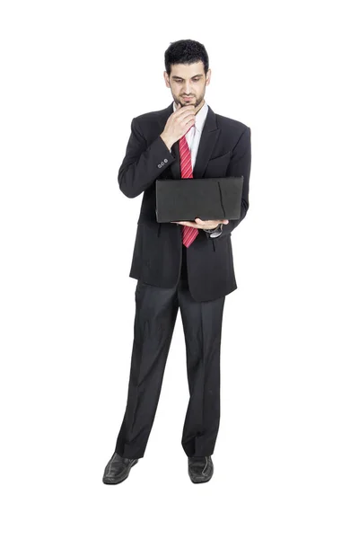 Портрет Молодого Бизнесмена Смотрящего Свой Ноутбук Студии Изолированного Белом Фоне — стоковое фото
