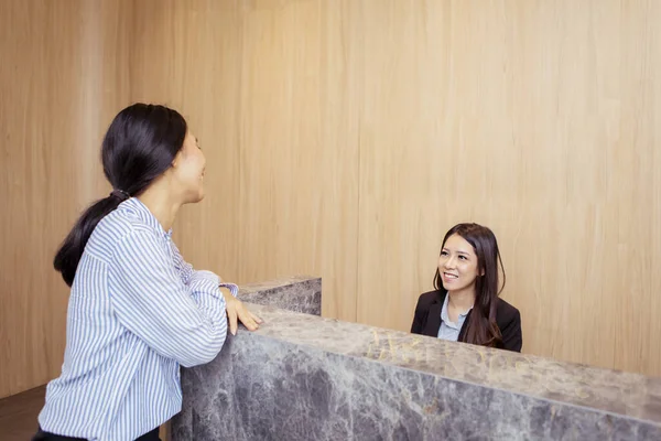 Portret Pięknej Azjatki Siedzącej Biurku Recepcjonistki Szczęśliwie Rozmawiającej Klientką Biurze — Zdjęcie stockowe