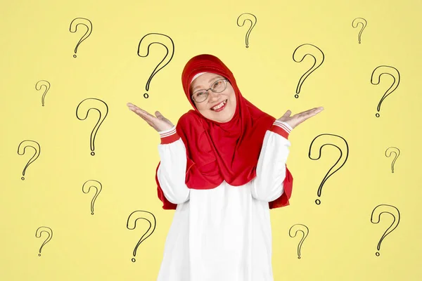 質問とカメラで笑顔シニアイスラム教徒の女性の肖像マークの背景 — ストック写真