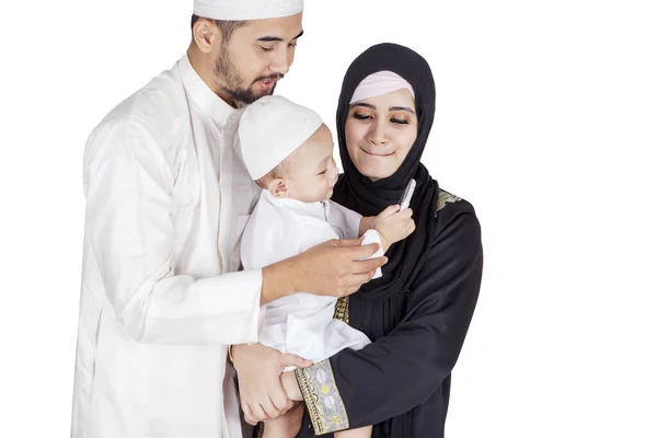 可爱的穆斯林小男孩和他的父母站在演播室里用手机 被白色背景隔离 — 图库照片