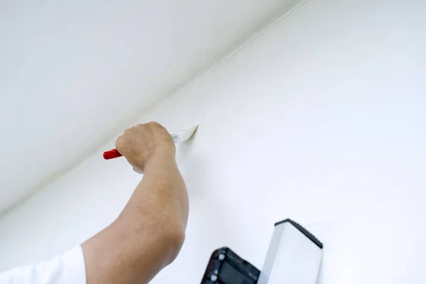 Feche Mão Reparador Segurando Pincel Enquanto Pinta Parede — Fotografia de Stock