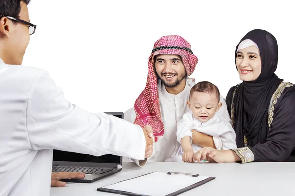 Familia Musulmana Sonriendo Estrechando Mano Con Médico Aislado Sobre Fondo —  Fotos de Stock